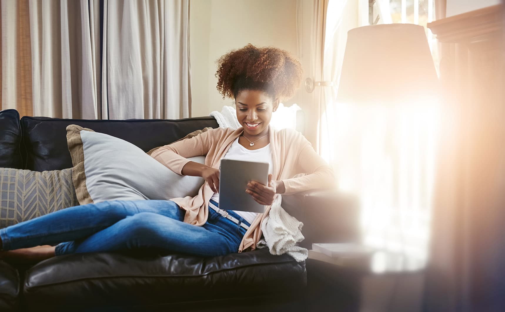 Woman looking at tablet on couch