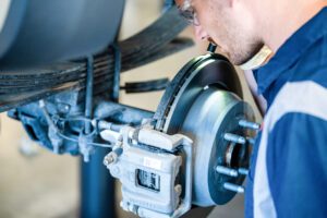 A Burt Brothers technician inspecting a brake caliper