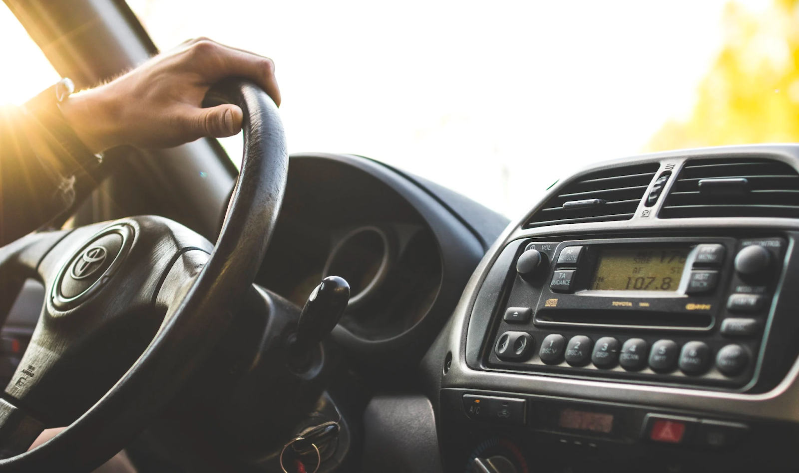 A hand on the steering wheel of a car