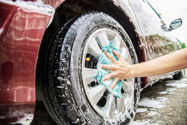 A person washing a car tire