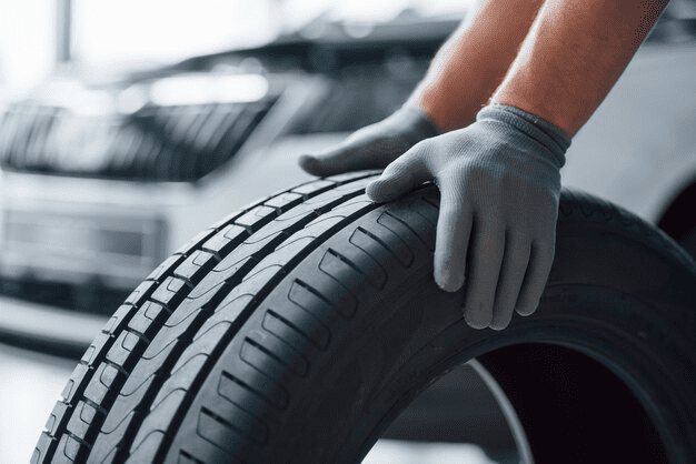 A close-up of a person inspecting new tire