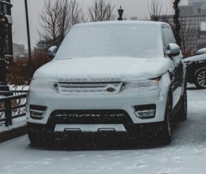 Image of a parked Range Rover covered in snow.