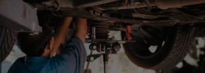 A mechanic working on a car's suspension