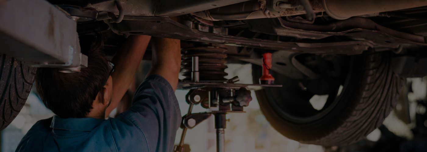 A mechanic working on a car's suspension